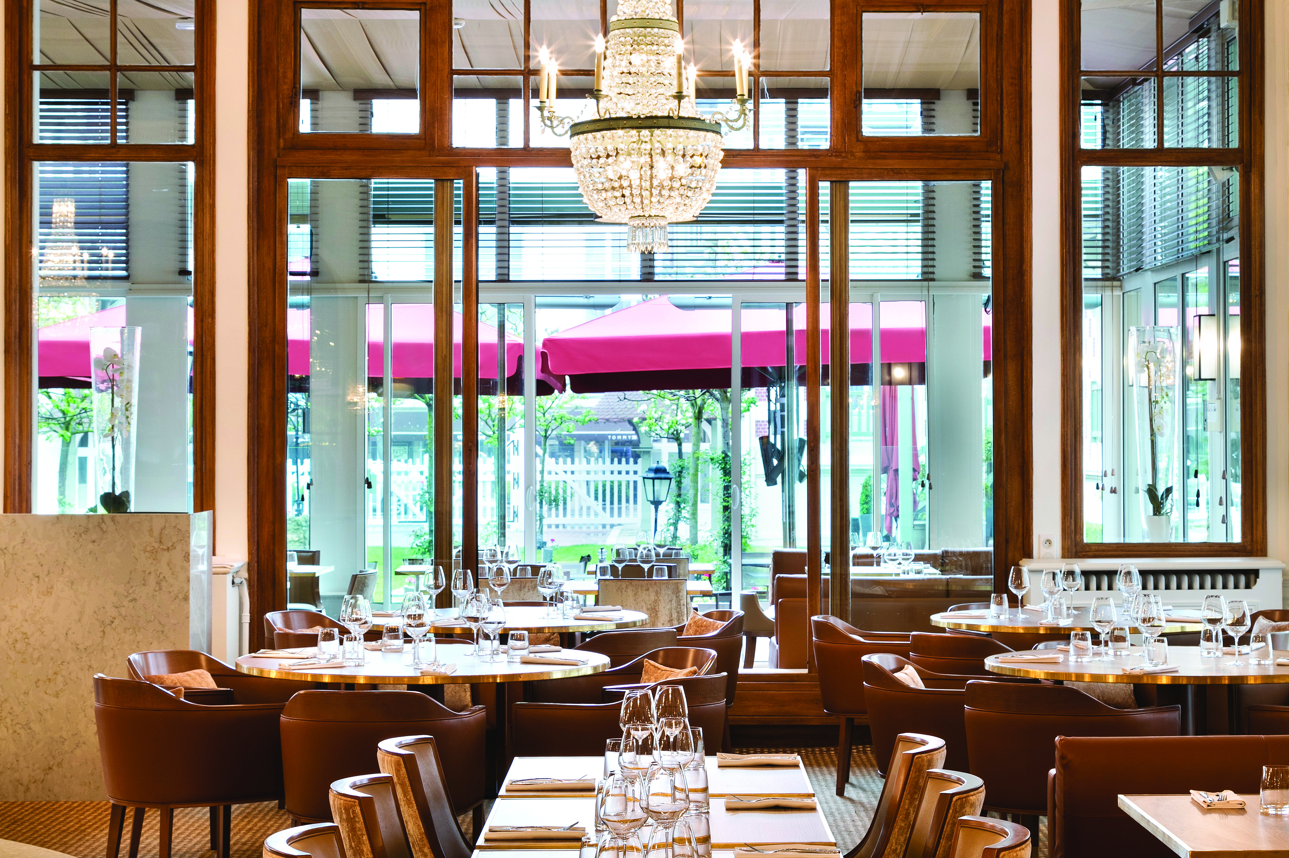 Indoor dining area with wood pannelling on the walls, wooden seats and dining tables set up