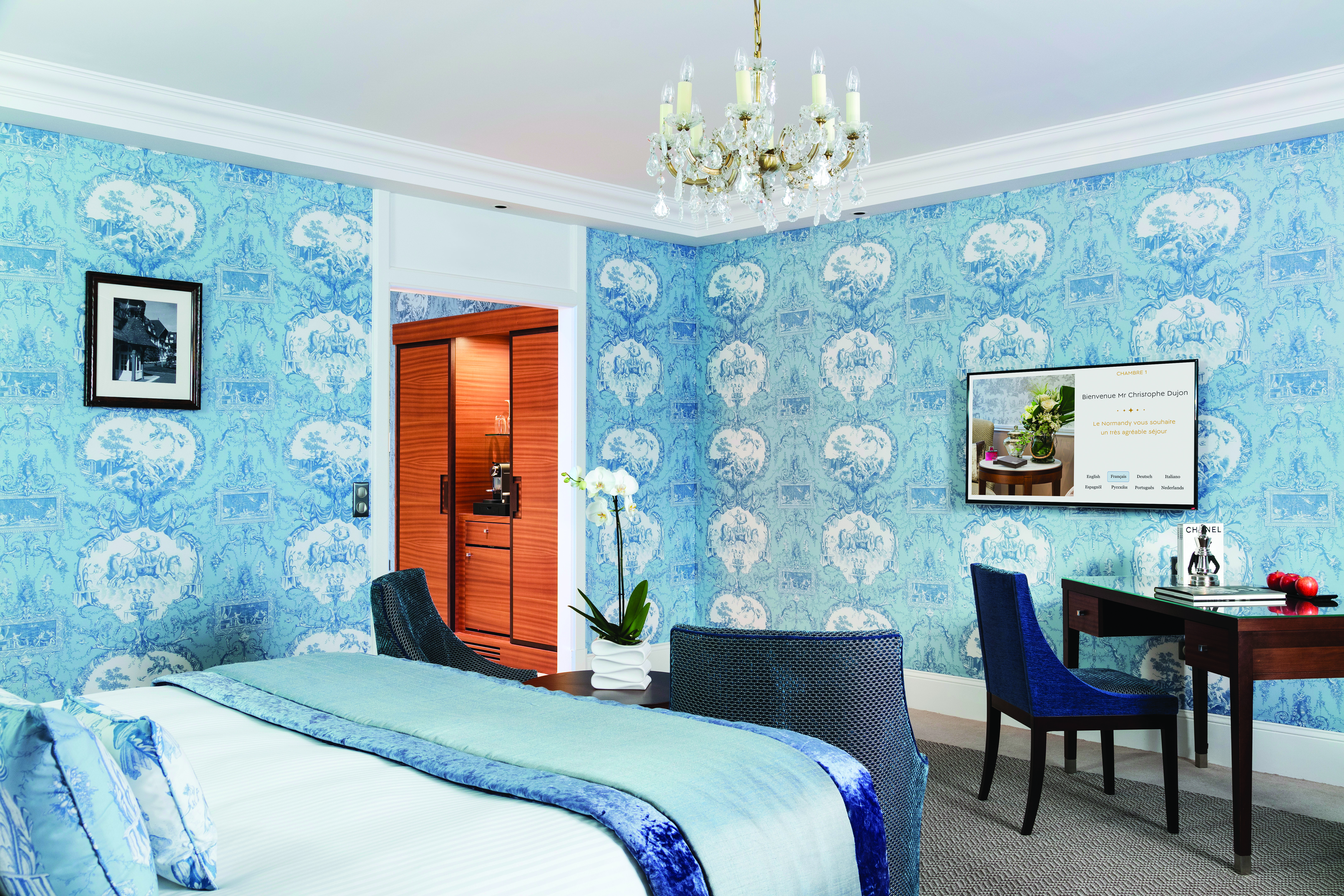 Double room at the Hotel Barriere with blue colour scheme, a double bed, large flat screen television and walk in wardrobe