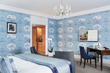 Double room at the Hotel Barriere with blue colour scheme, a double bed, large flat screen television and walk in wardrobe