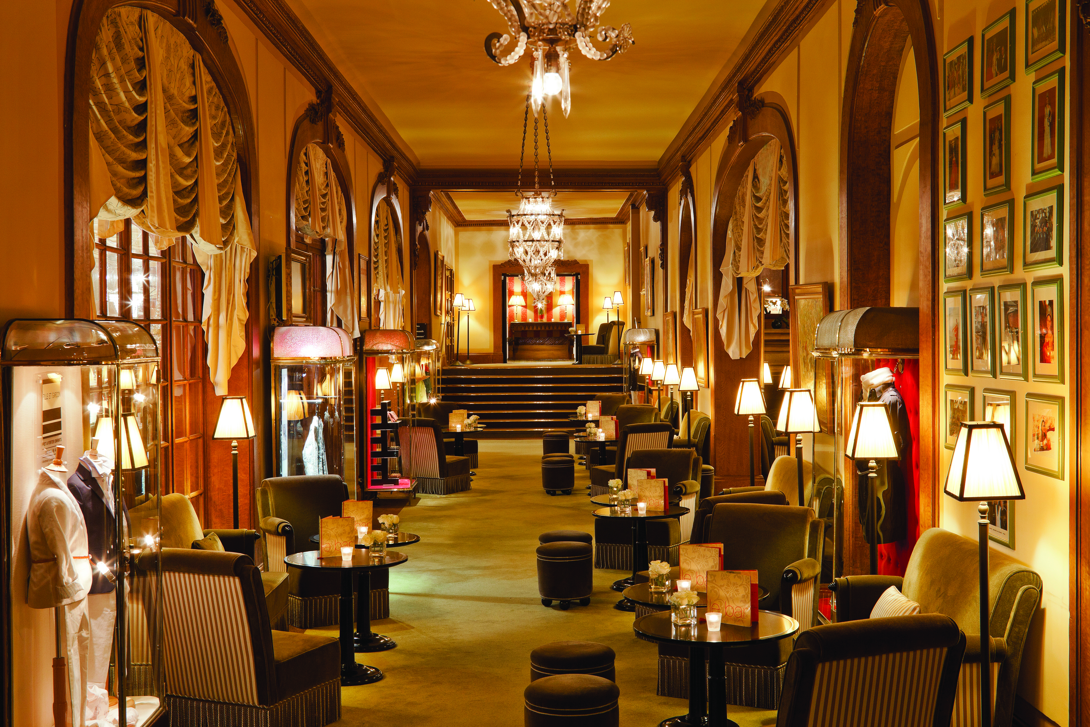 Hotel Normandy Barriere Normandy lounge area with drapes chandeliers and several cabinets with period costumes