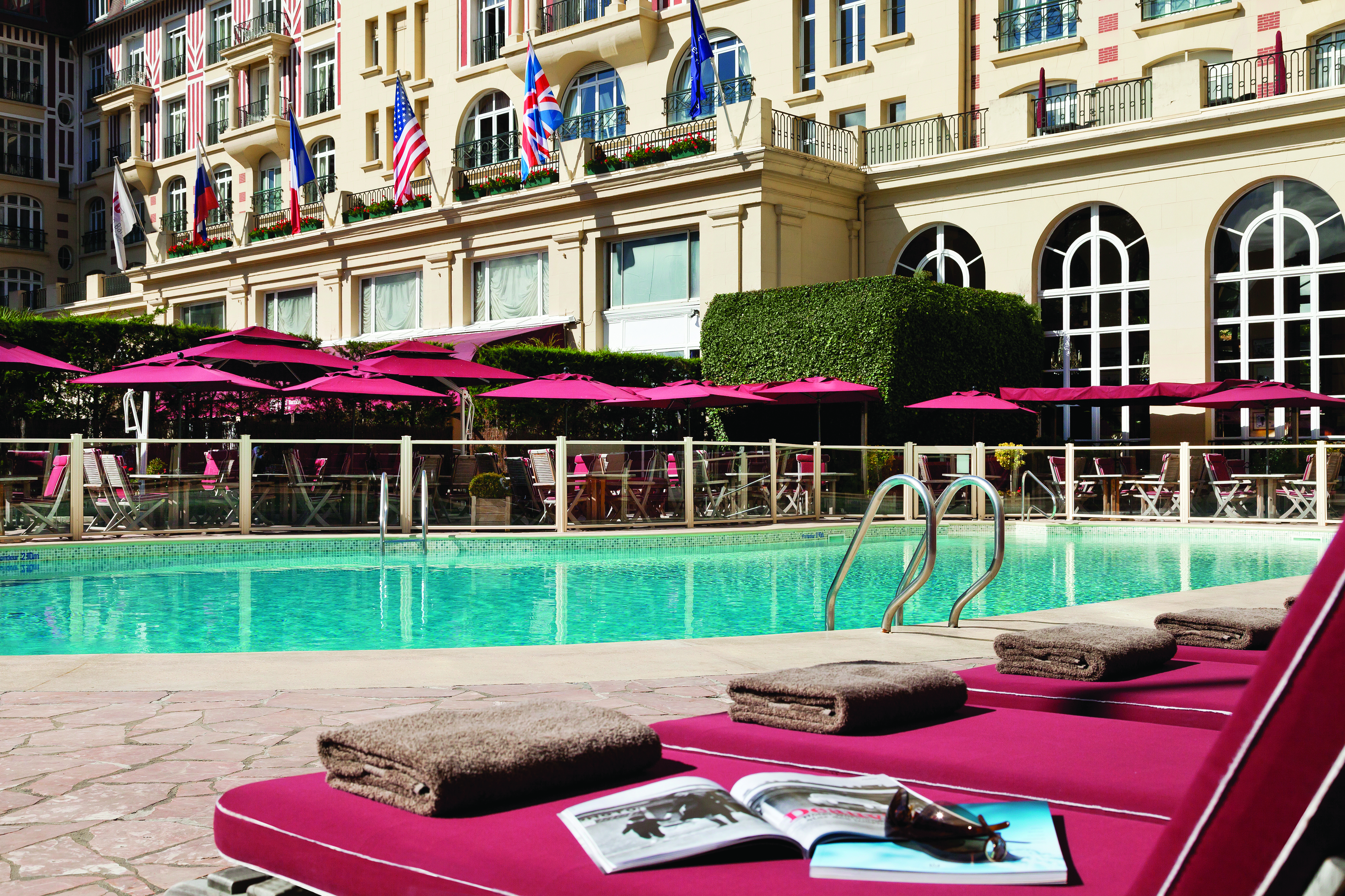 Hotel Royal Barriere pool, sun loungers, umbrellas, hotel building in background