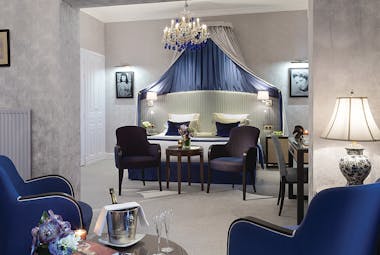 Hotel Royal Barriere prestige suite, elegant decor, blue velvet armchairs, seperate seating area, canopied bed