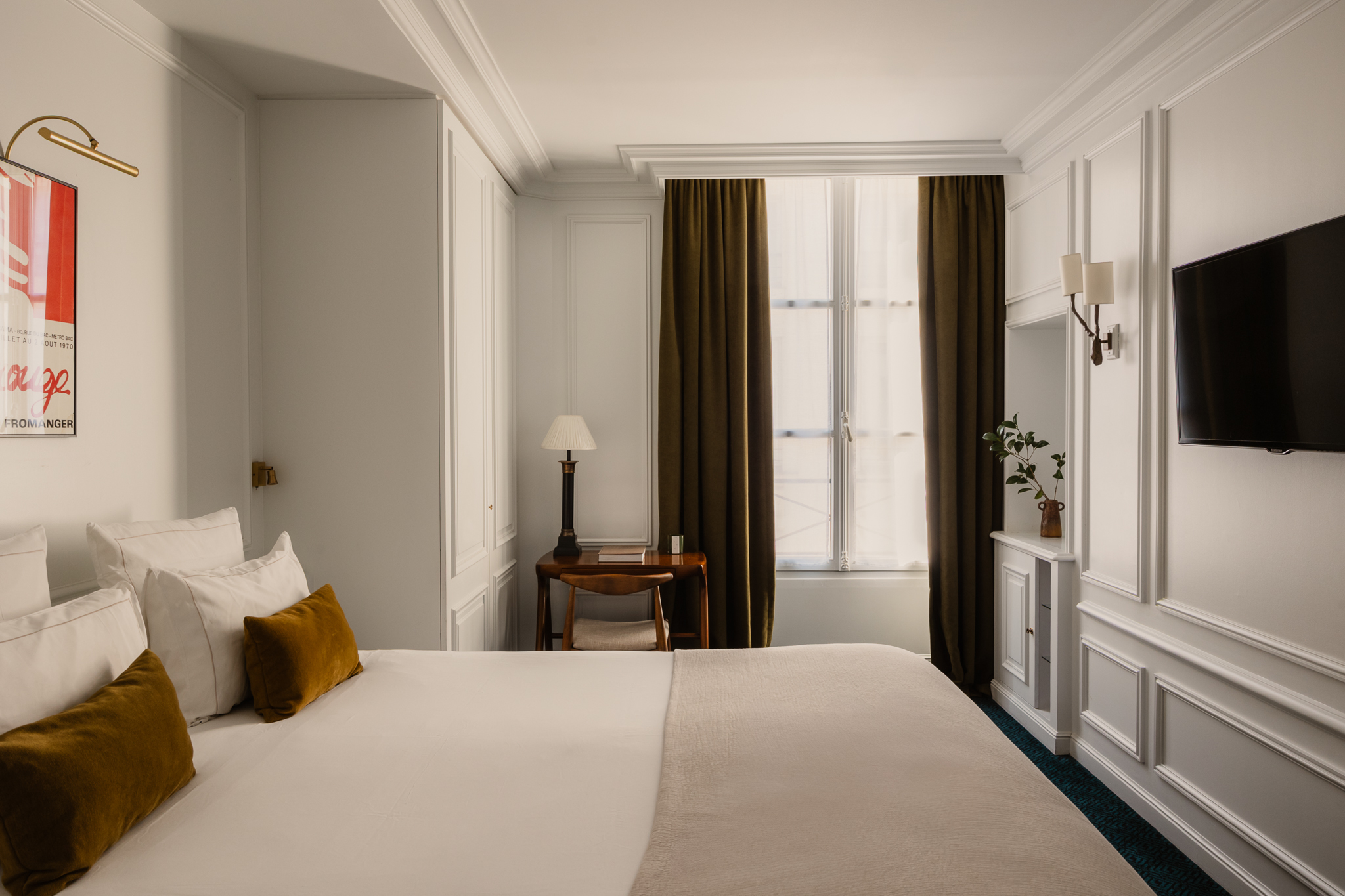 Hotel Bourgogne et Montana Superior room with bright, light, neutral palette, panelled white walls, TV, double bed and gold cushions