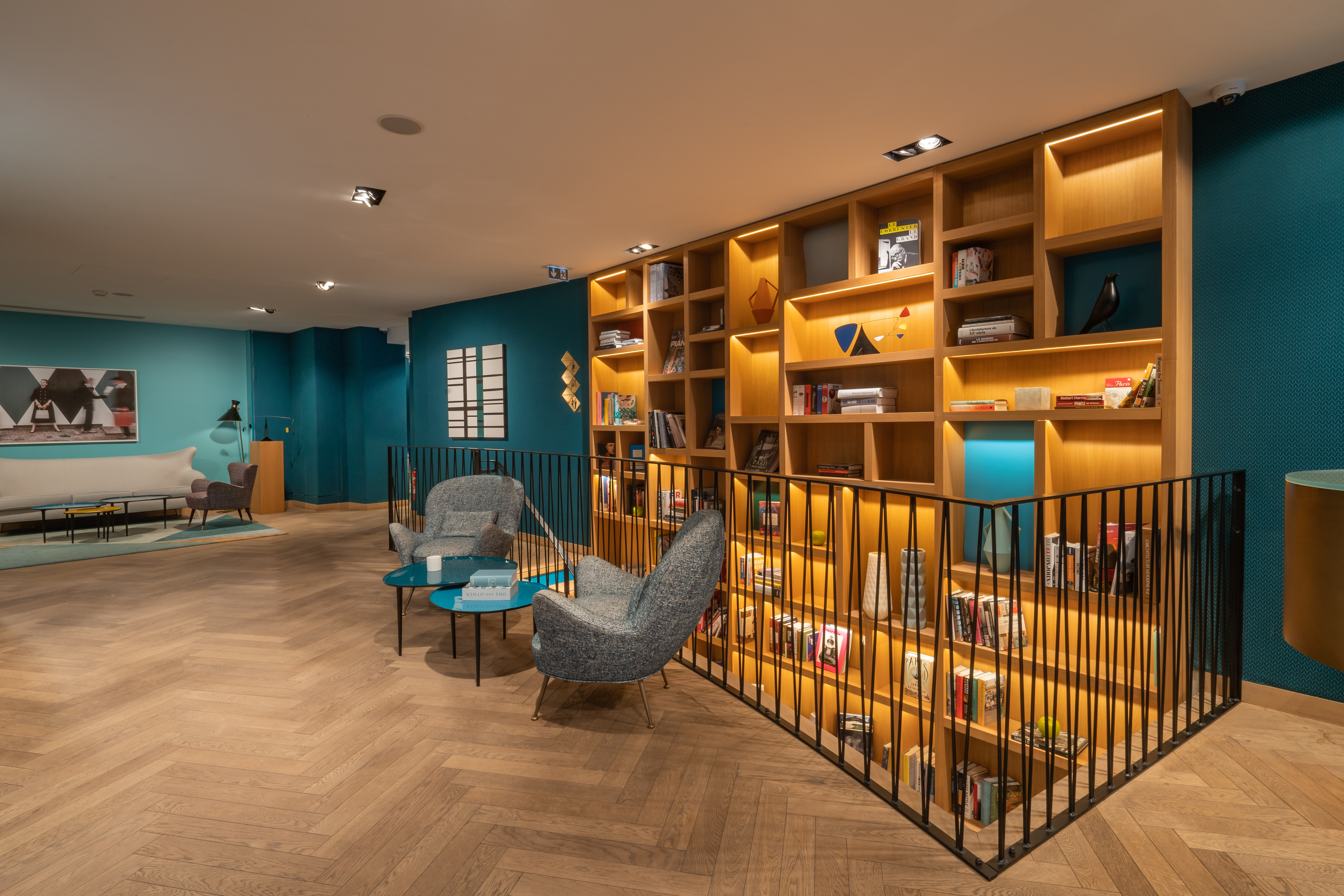 Hotel Artus lobby with multi-floor bookcase, blue walls, and statement grey furnishings