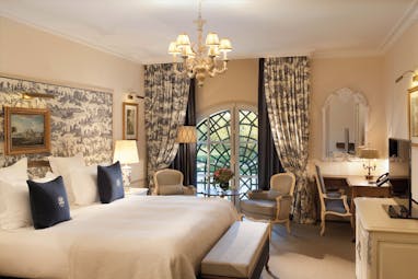 Auberge du Jeu de Paume Paris deluxe bedroom with blue and white patterned curtains and chandelier
