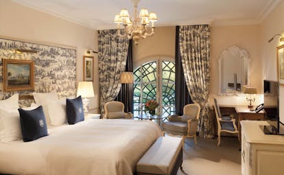 Auberge du Jeu de Paume Paris deluxe bedroom with blue and white patterned curtains and chandelier