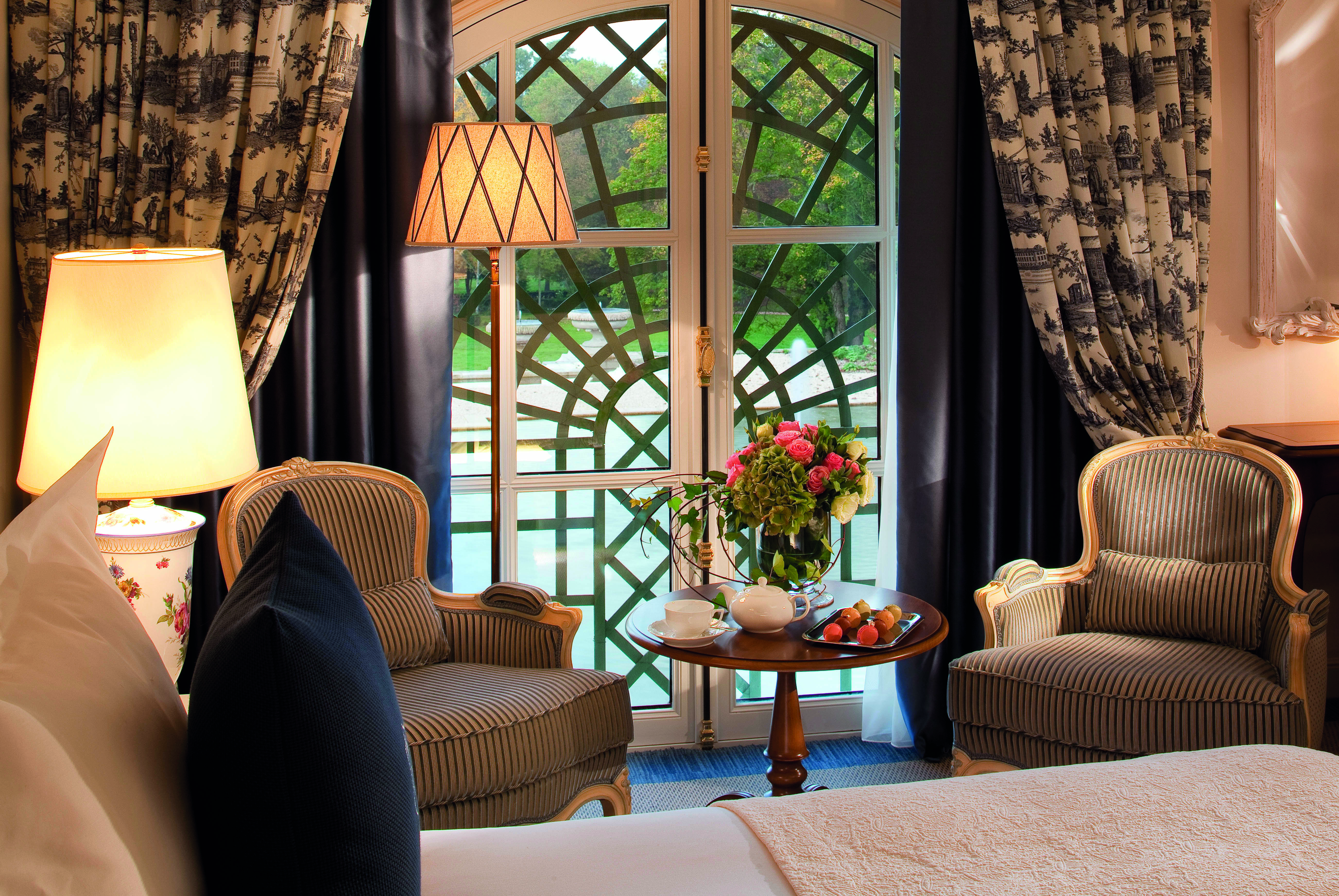 Auberge du Jeu de Paume Paris deluxe park bedroom blue and white curtains striped armchairs and a table