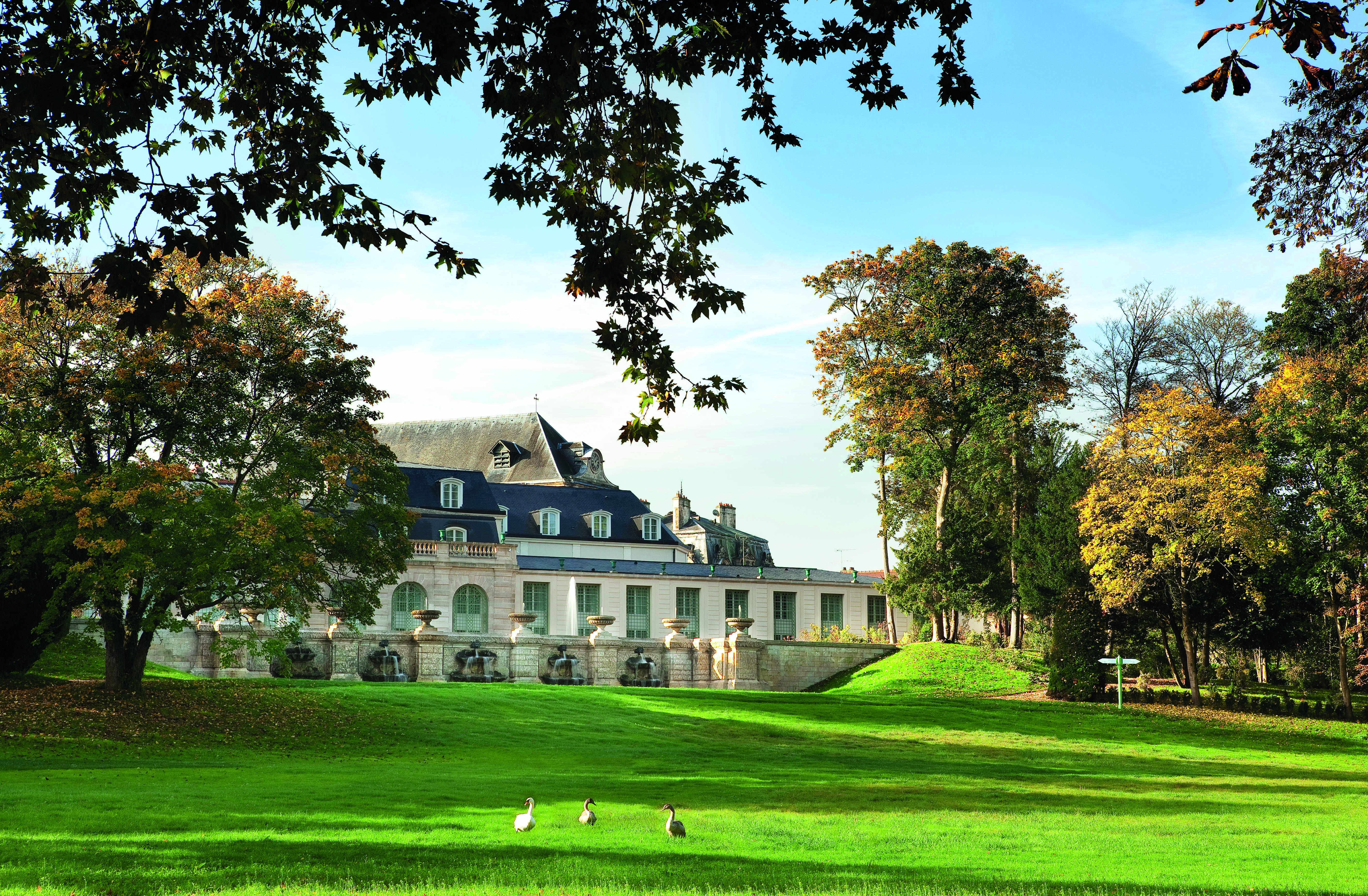 Auberge du Jeu de Paume Paris exterior lawn large white building with grey roof overlooking a lawn and trees