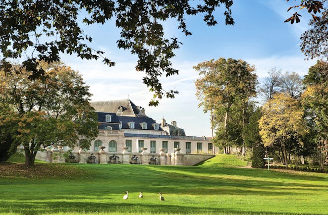 Auberge du Jeu de Paume Paris exterior lawn large white building with grey roof overlooking a lawn and trees