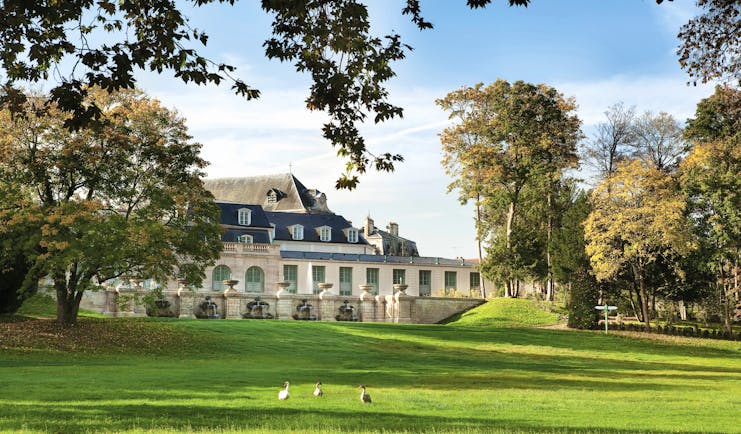 Auberge du Jeu de Paume Paris exterior lawn large white building with grey roof overlooking a lawn and trees