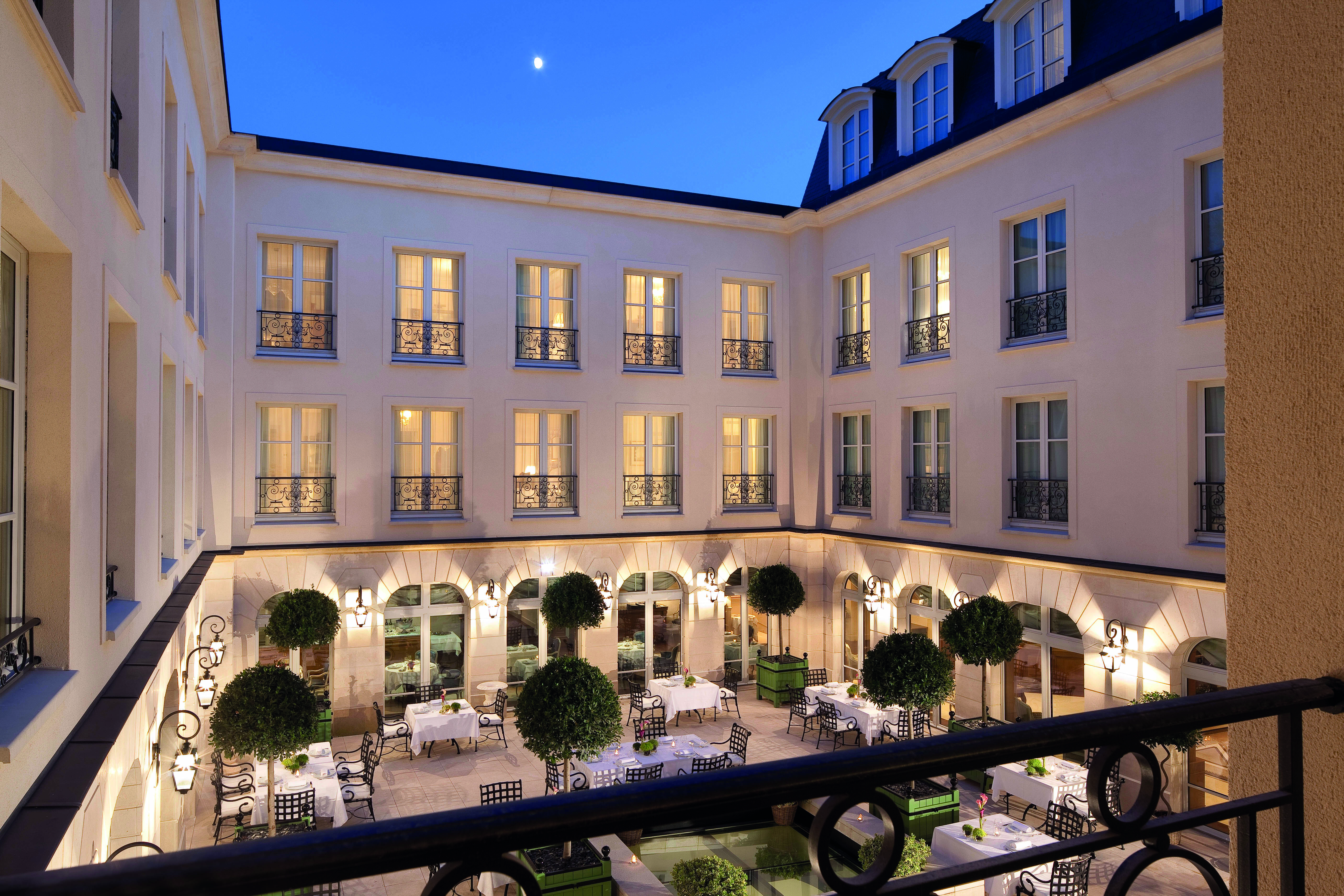 Auberge du Jeu de Paume Paris exterior courtyard with several tables and chairs overlooked by a white building