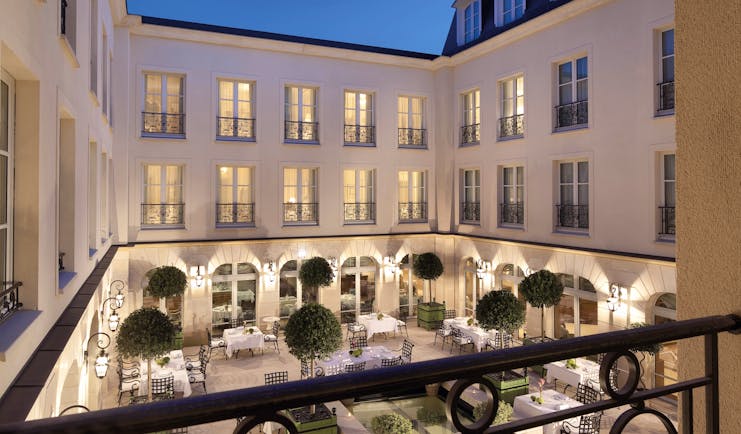Auberge du Jeu de Paume Paris exterior courtyard with several tables and chairs overlooked by a white building
