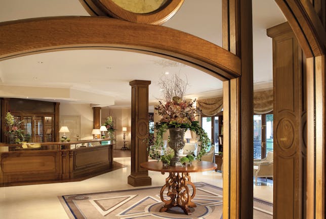 Auberge du Jeu de Paume Paris lobby with wooden beams table with large floral arrangement chandelier