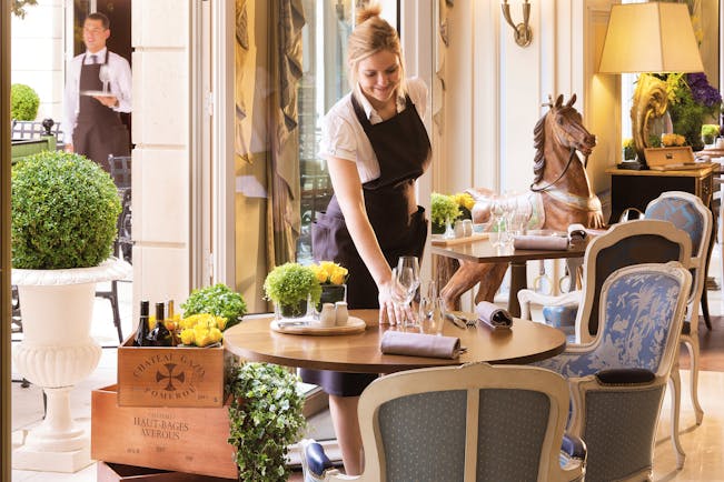 Auberge du Jeu de Paume Paris restaurant dining waitress setting table in front of a carved wooden rocking horse