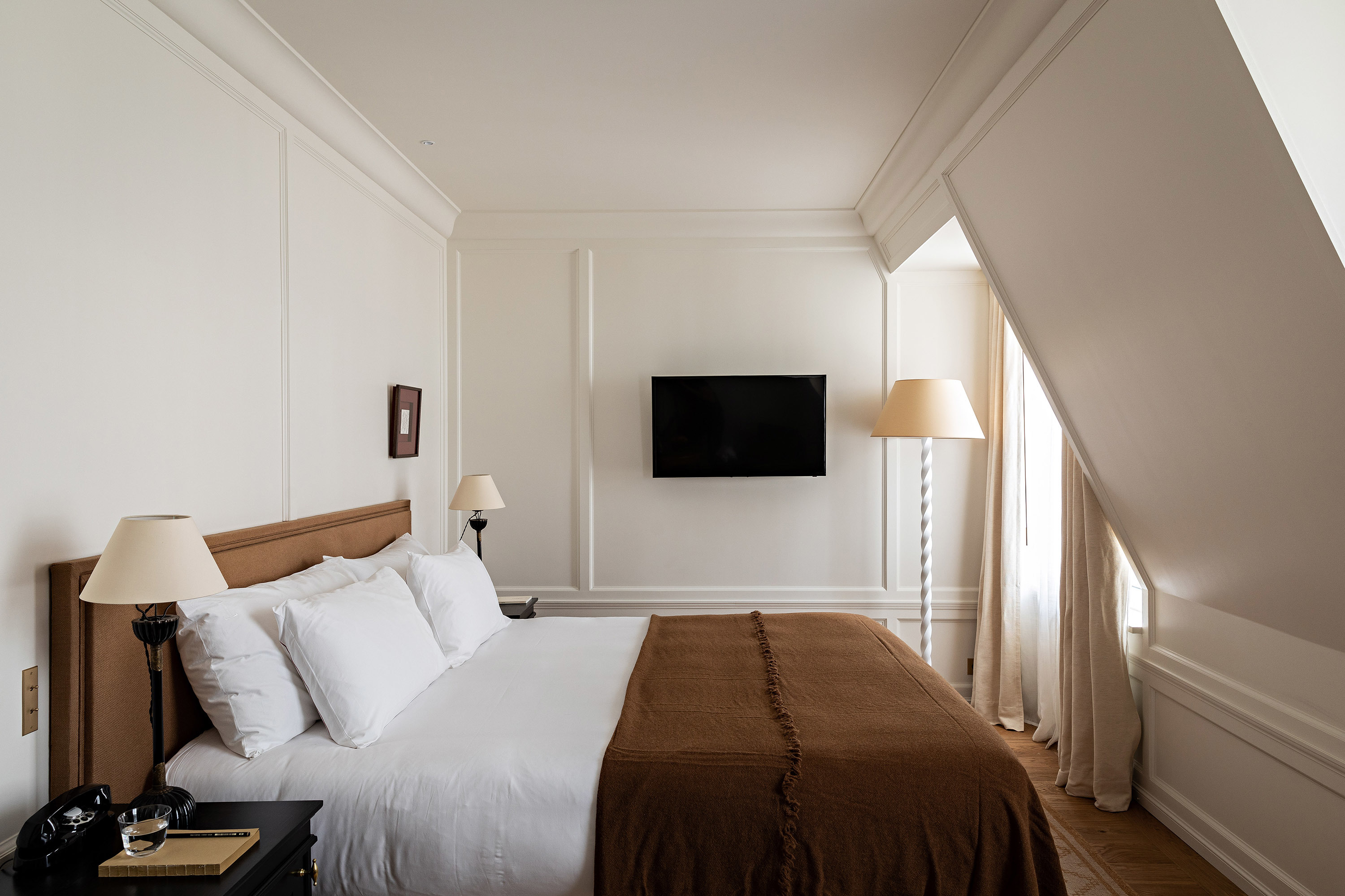 Hotel Balzac Boudoir Room with sloped ceiling, double bed with white bed linen and brown throw, and white panelled walls