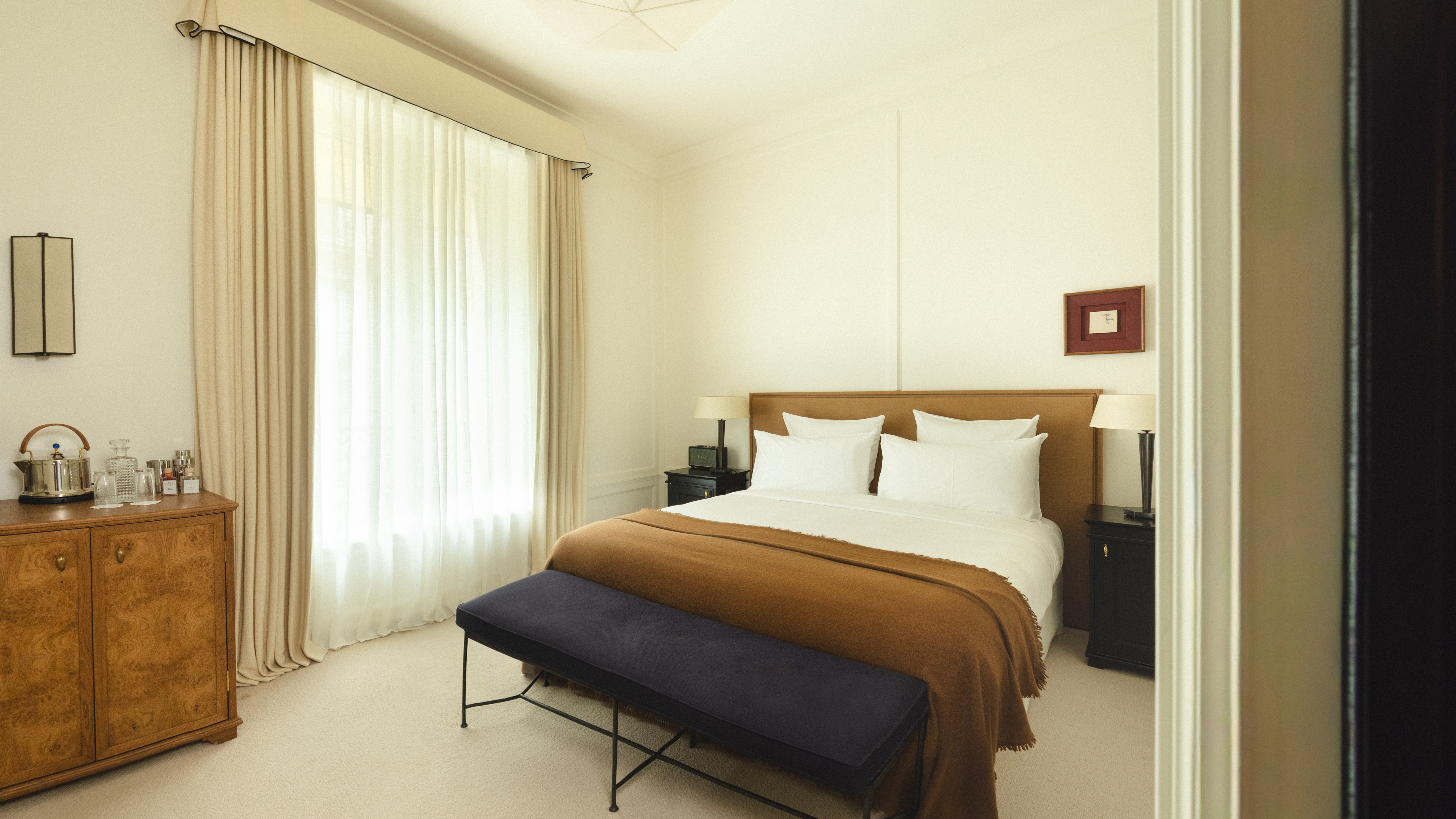 Hotel Balzac Boudoir Room with large windows, double bed, antique wooden furnishings and warm colour palette