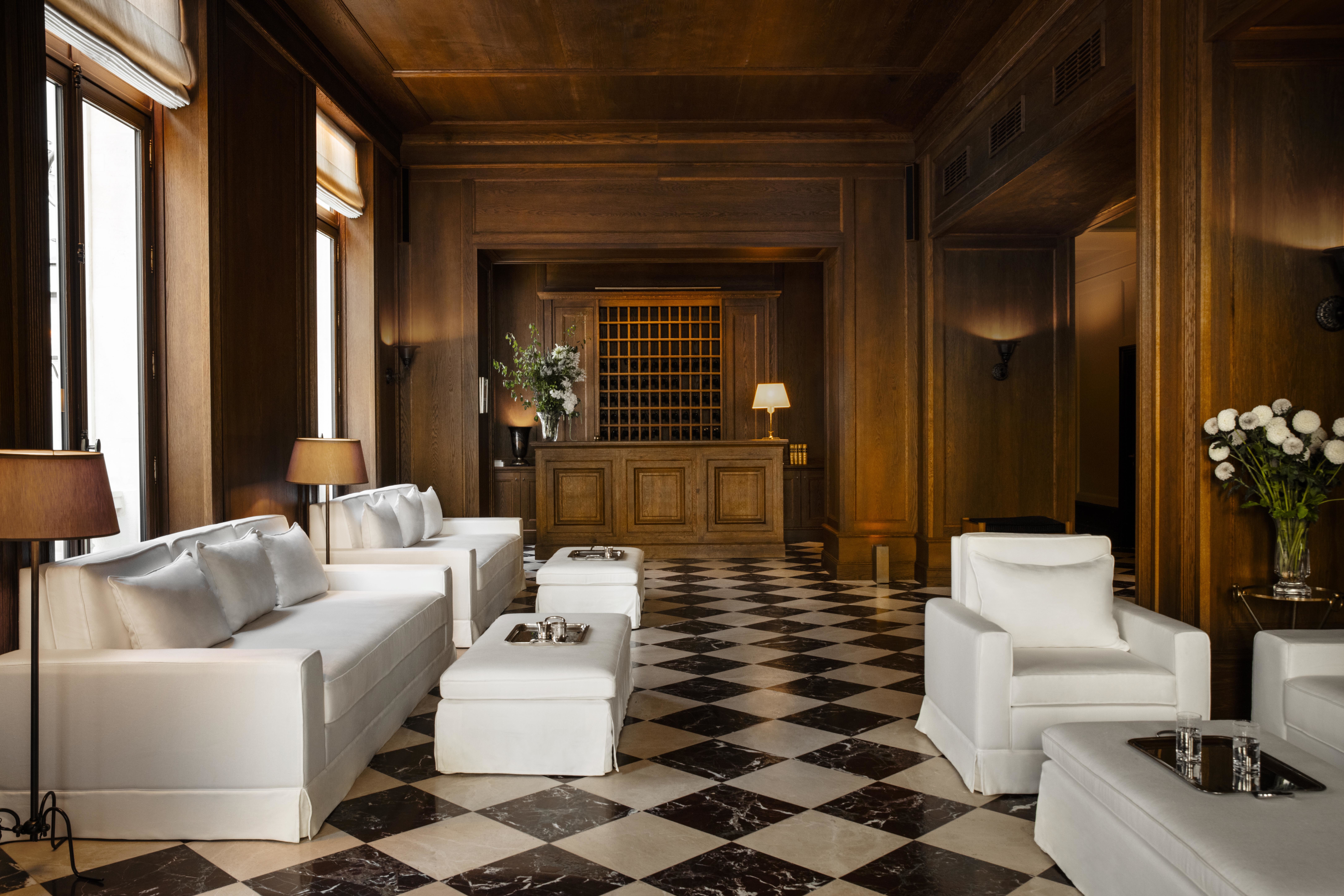 Hotel Balzac lobby with black and white checkered marble floor, white sofas, and panelled wooden walls and reception desk