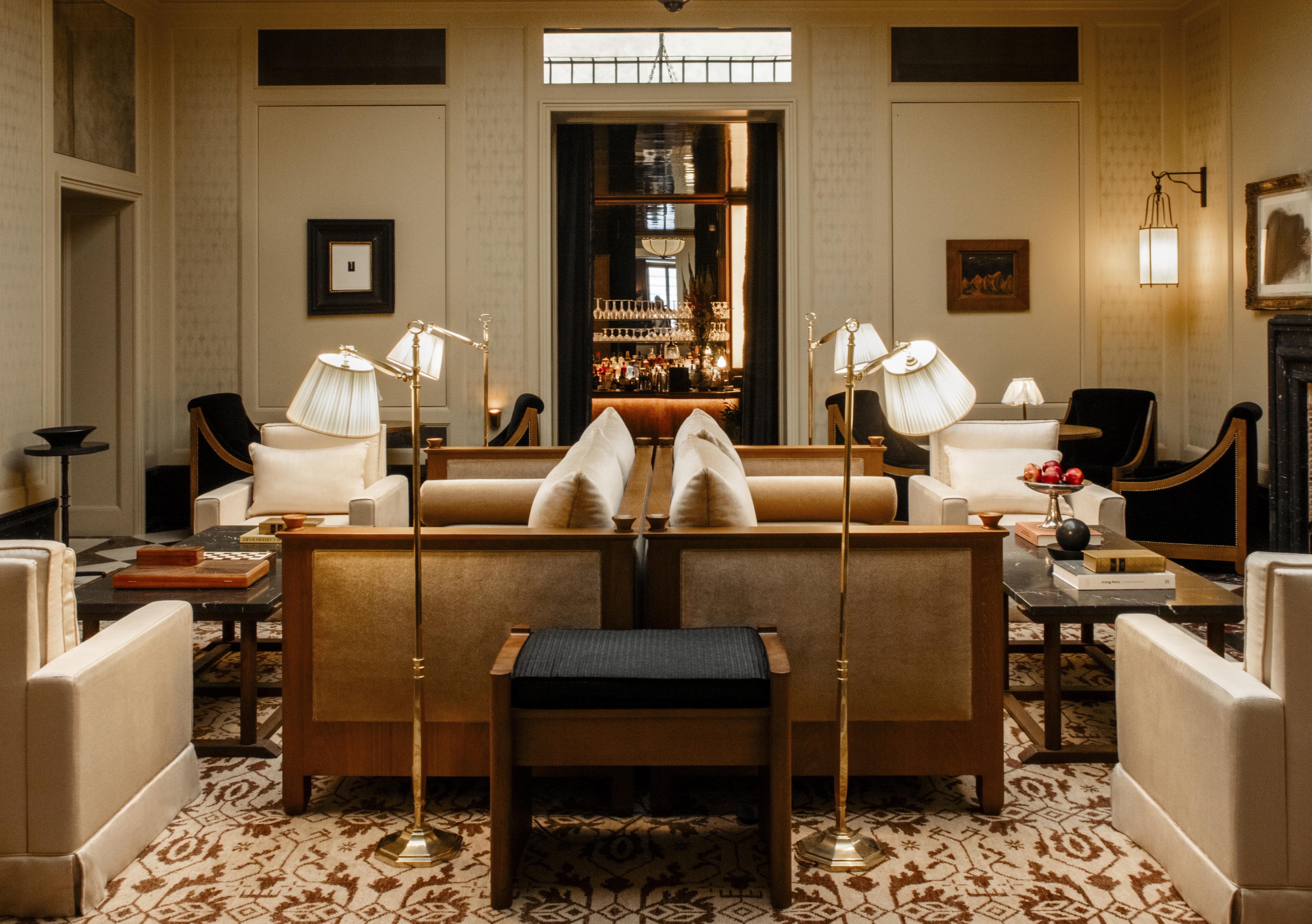 Hotel Balzac lounge with plush gold sofas, worn antique rug, panelled walls, and lots of gold lamps