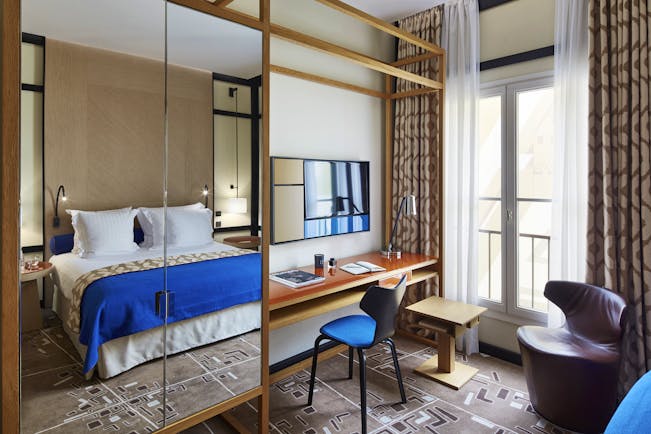 Hotel Bel Ami Paris bedroom with blue covers on bed and large mirror