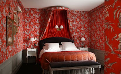 Hotel de Buci bourbon conde suite, double bed with canopy, red and colourful decor