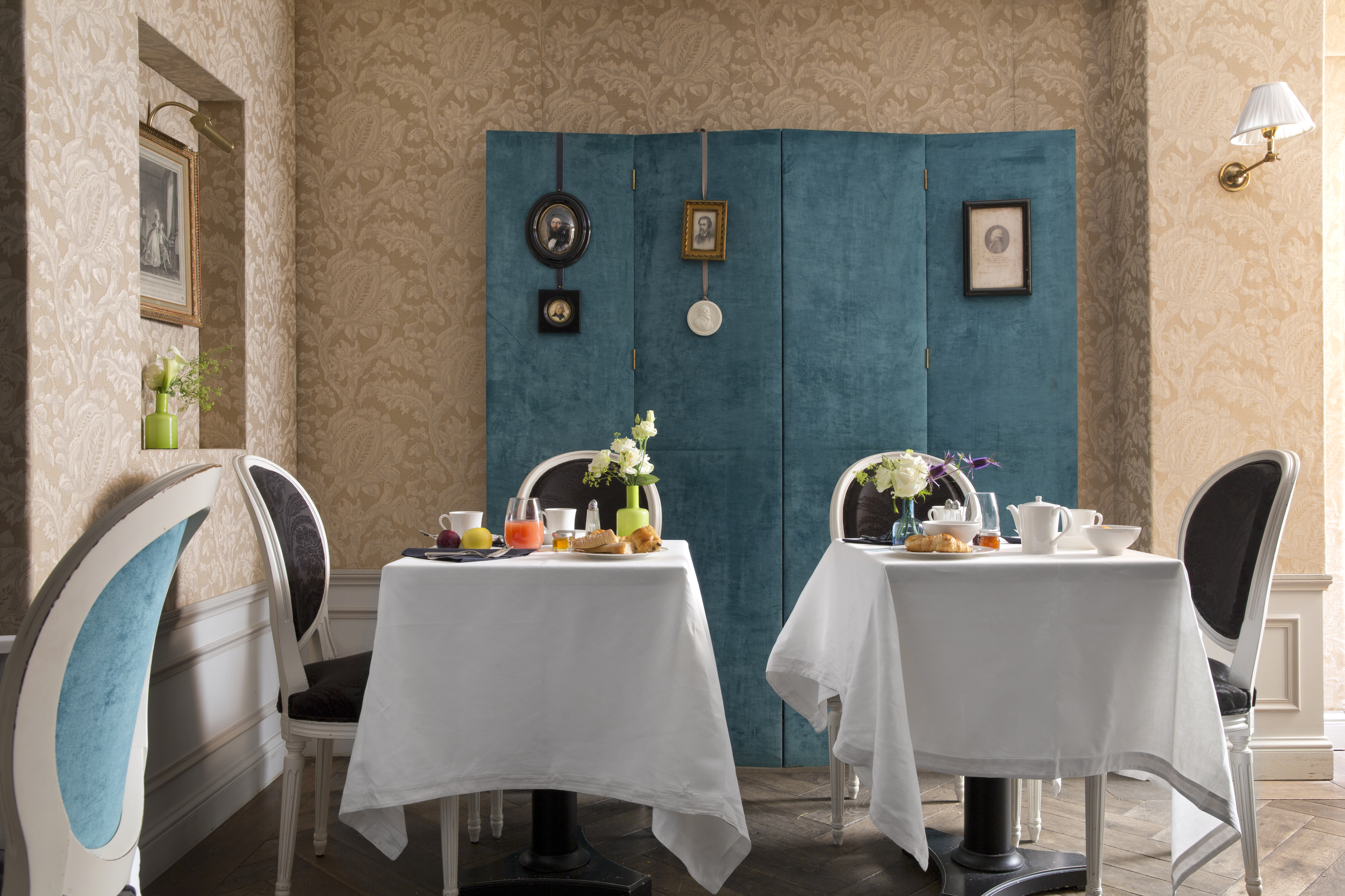 Hotel de Buci breakfast tables with food, bright room with colourful details