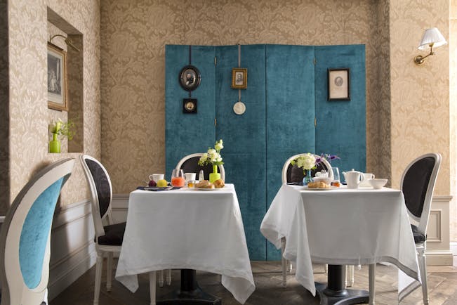 Hotel de Buci breakfast tables with food, bright room with colourful details