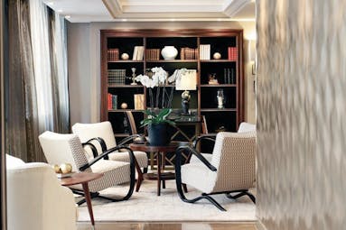 Hotel Esprit Saint Germain Paris lounge with white armchairs and floor to ceiling bookshelves