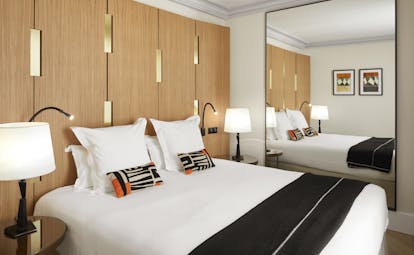 Hotel Montalembert king bed with white cover and large mirror