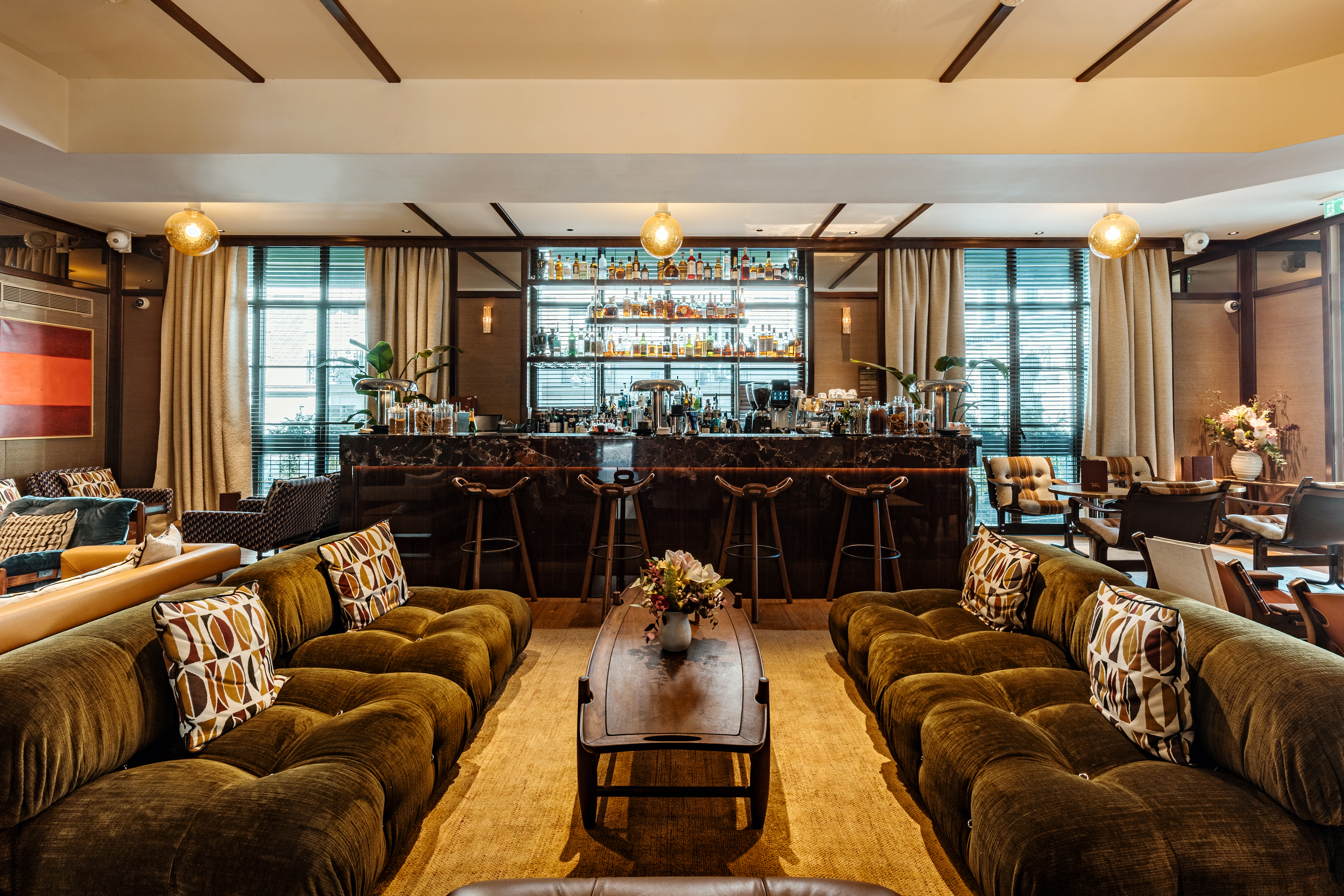 Hotel Norman Bar, with high bar and backlit liquor cabinets, and plush grass-green sofas
