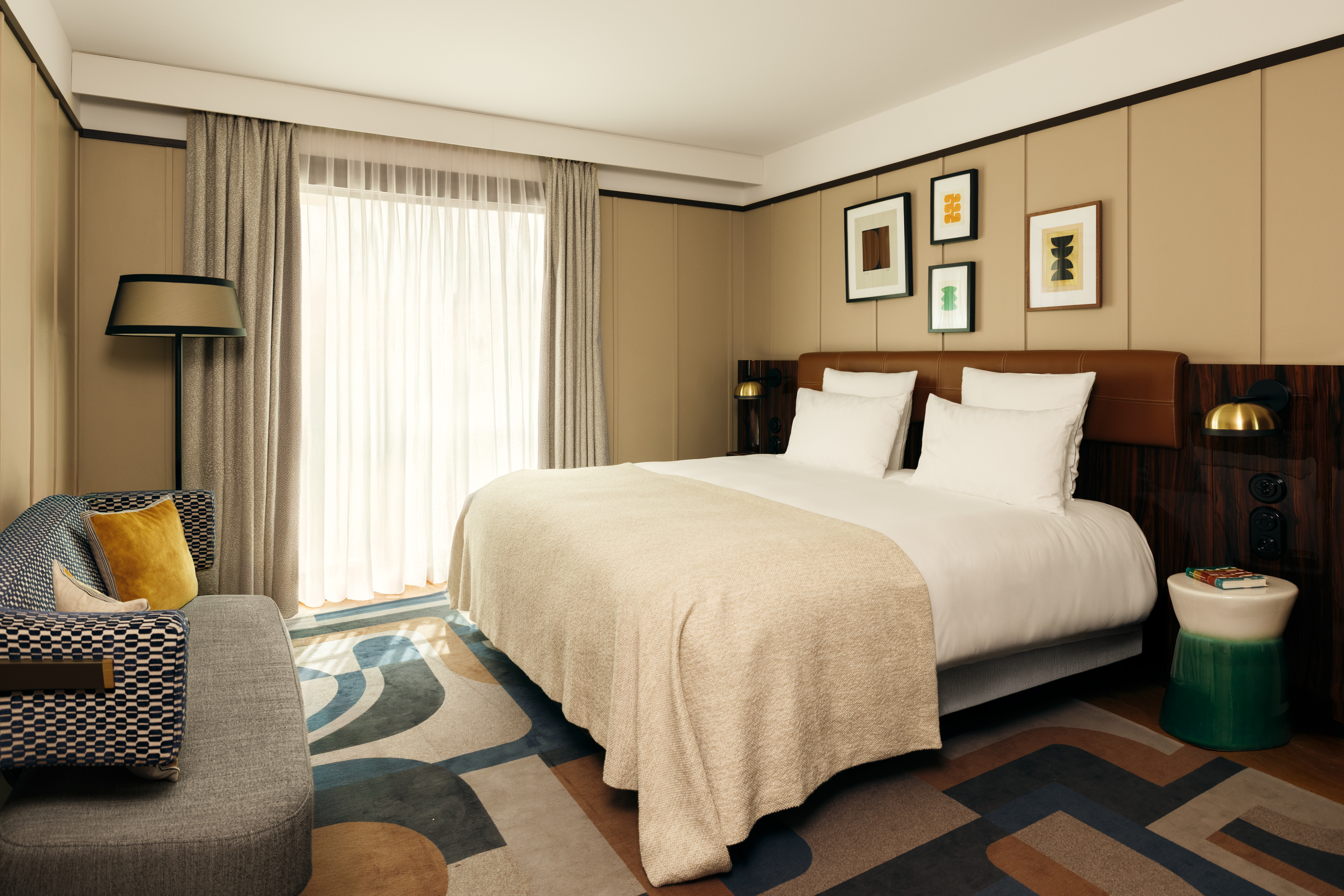 Hotel Norman Superior Room with art deco style, cream walls with small abstract artworks, and a sofa