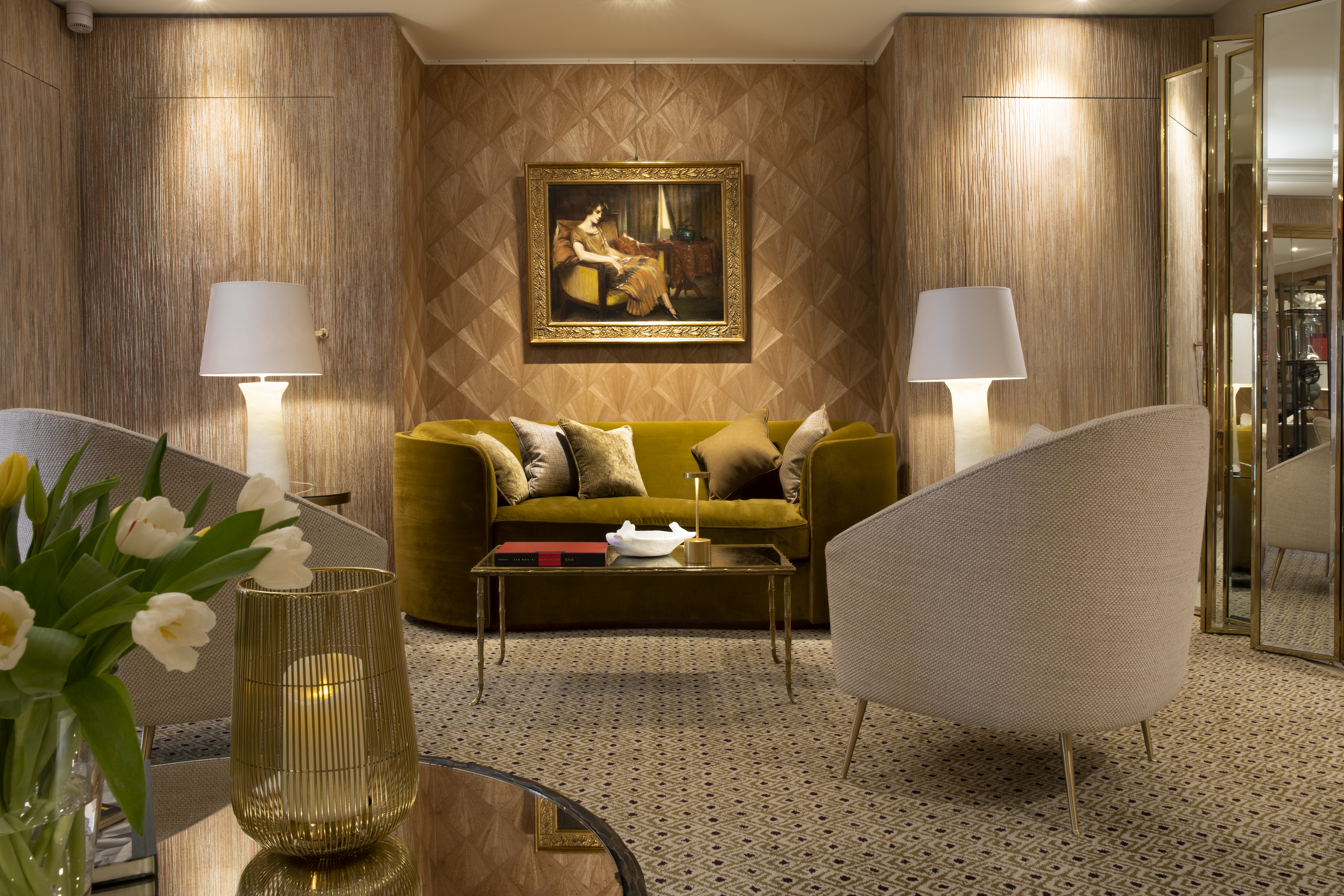 Lobby area with seating areas set out, paintings on the wall and lamp shades