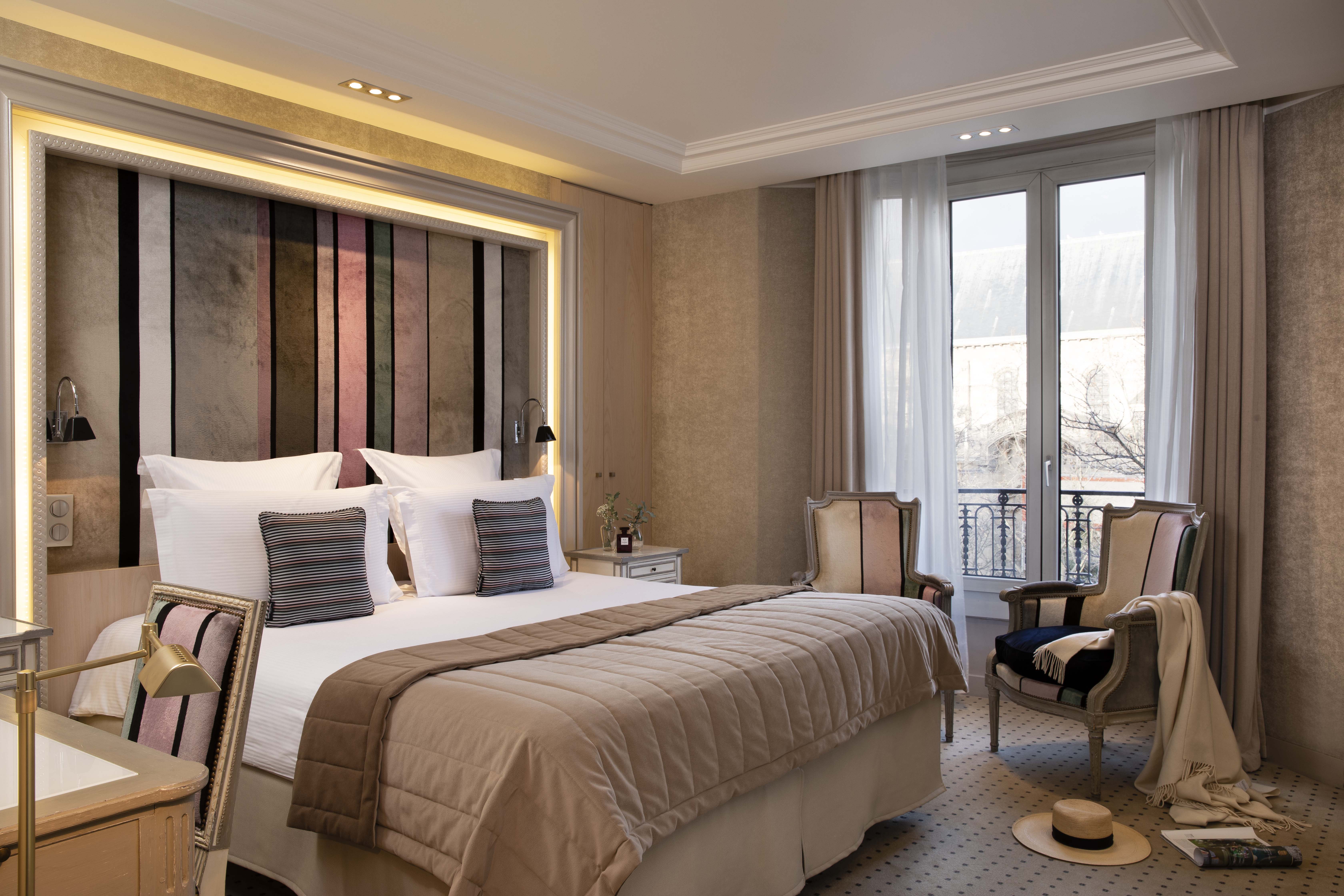 Superior bedroom wih large double bed, arm chairs and balcony 