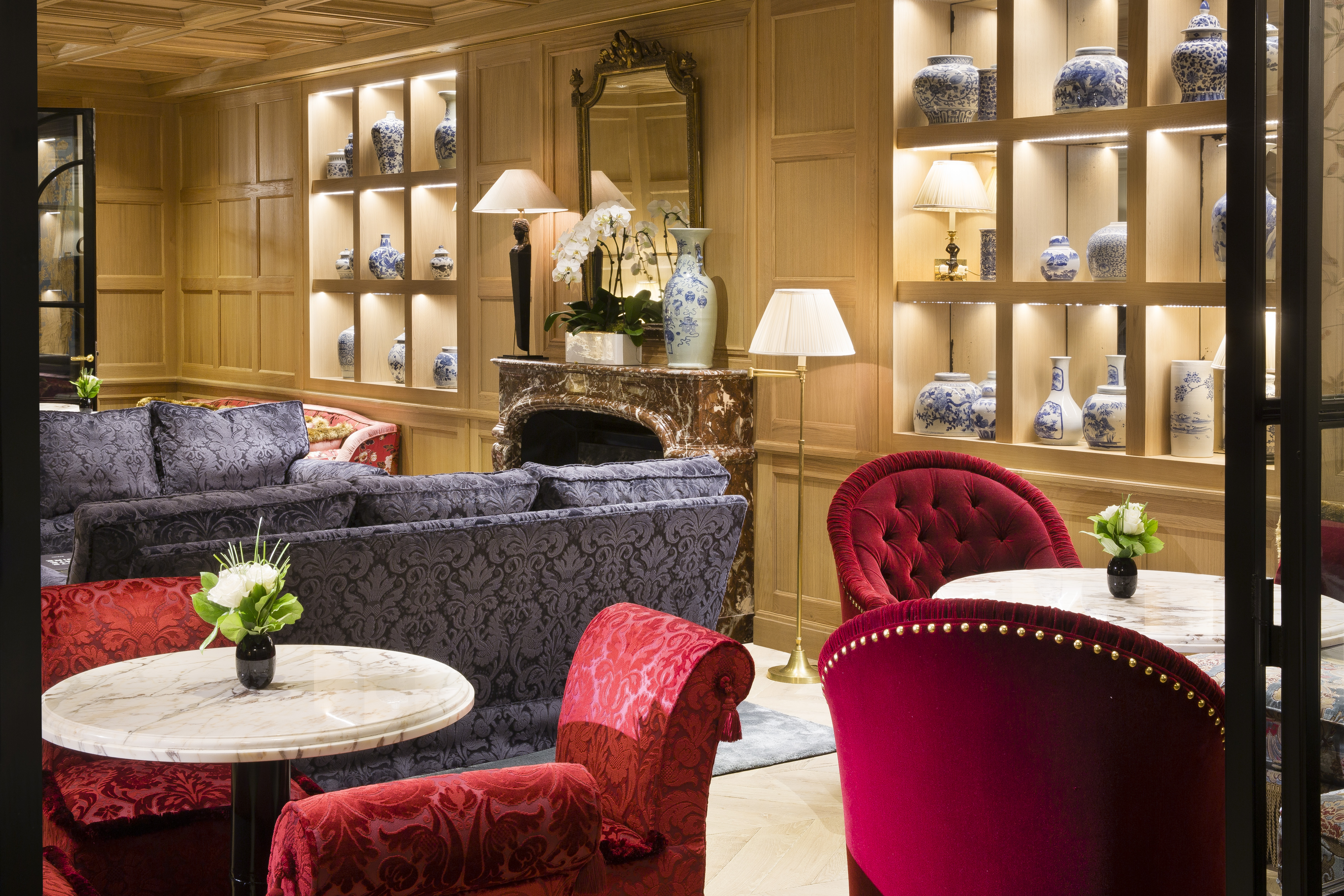 Wood lounge with red velvet arm chairs, purple sofas and ornaments 