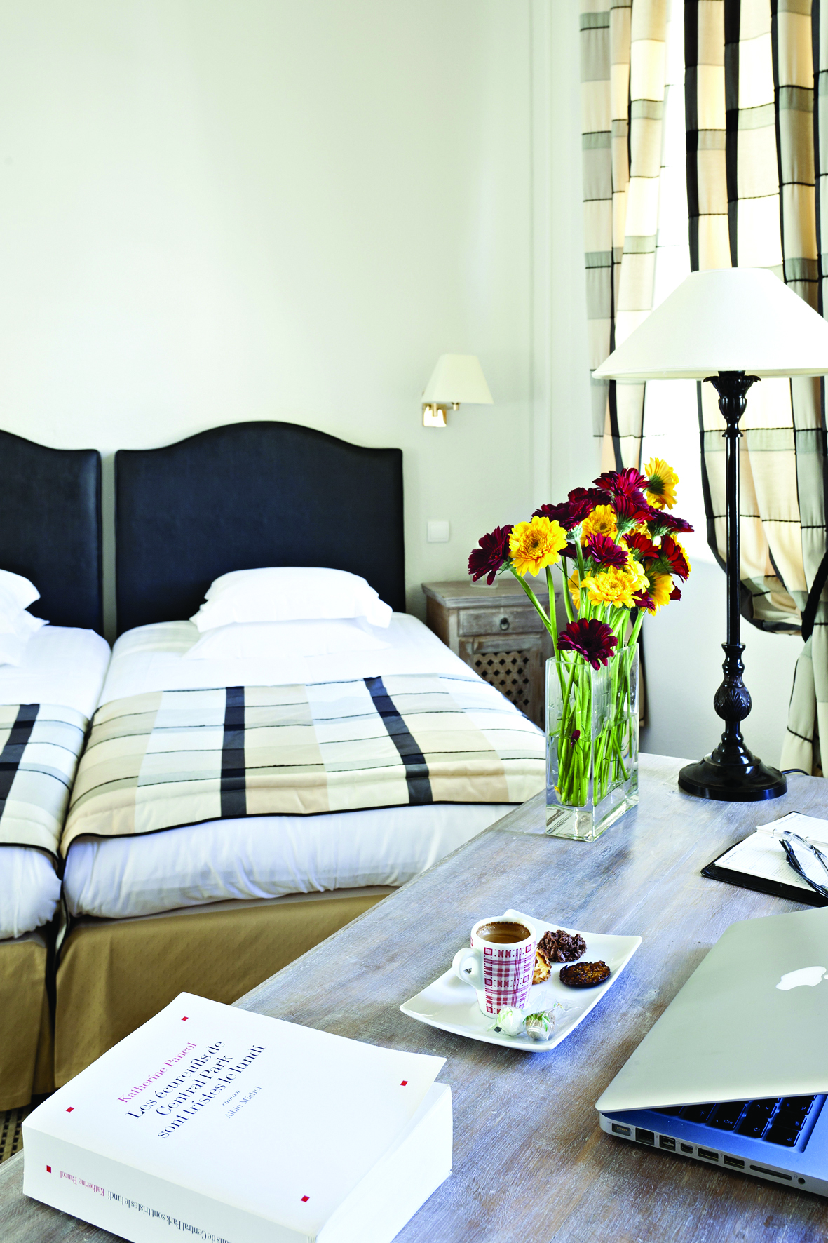 Twin room at the Hotel de l'Univers with black head boards and yellow and red flowers