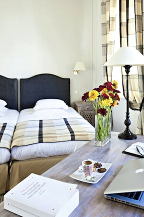 Twin room at the Hotel de l'Univers with black head boards and yellow and red flowers