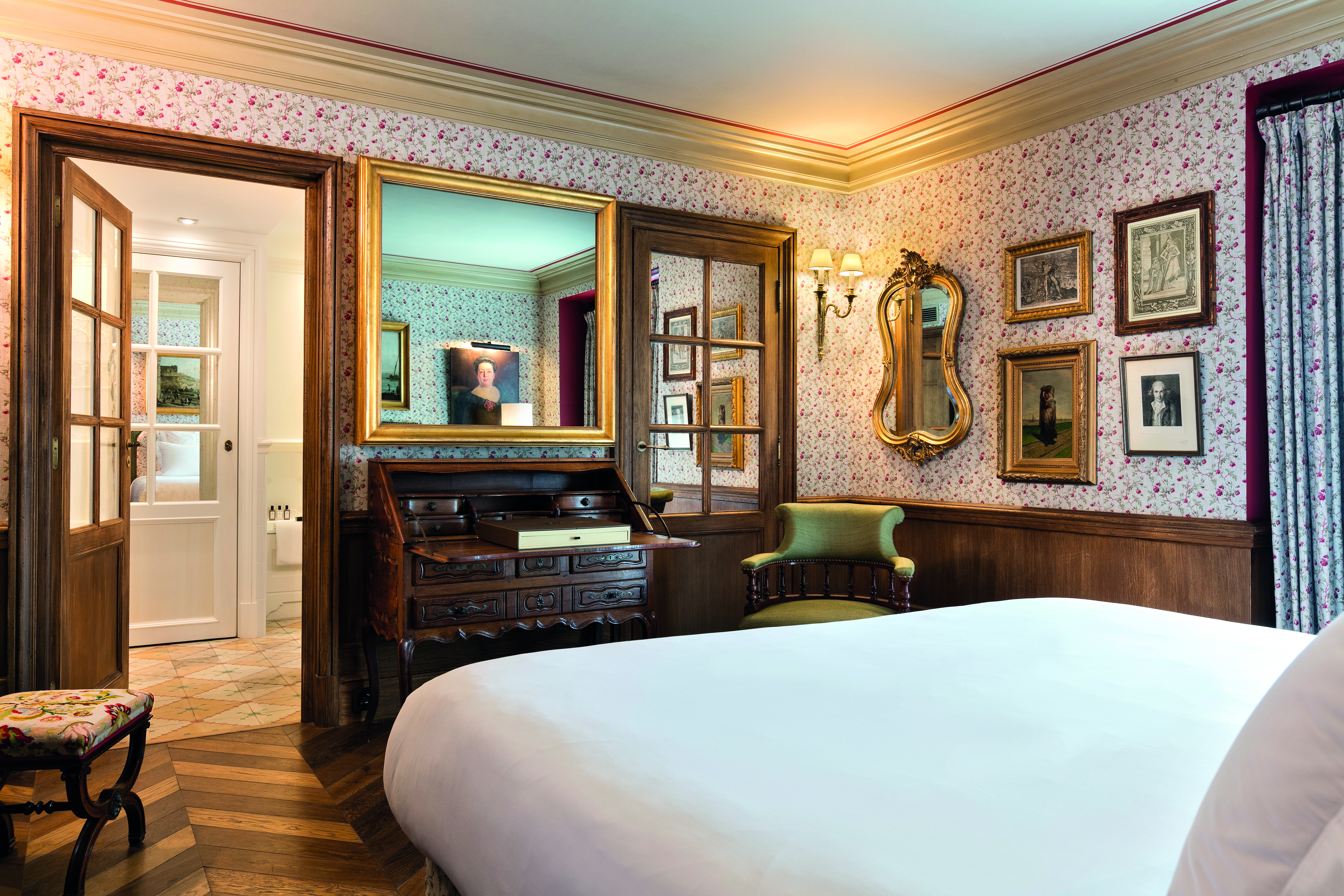 La Bastide de Gordes Provence deluxe bedroom with floral wallpaper and a large wooden writing bureau