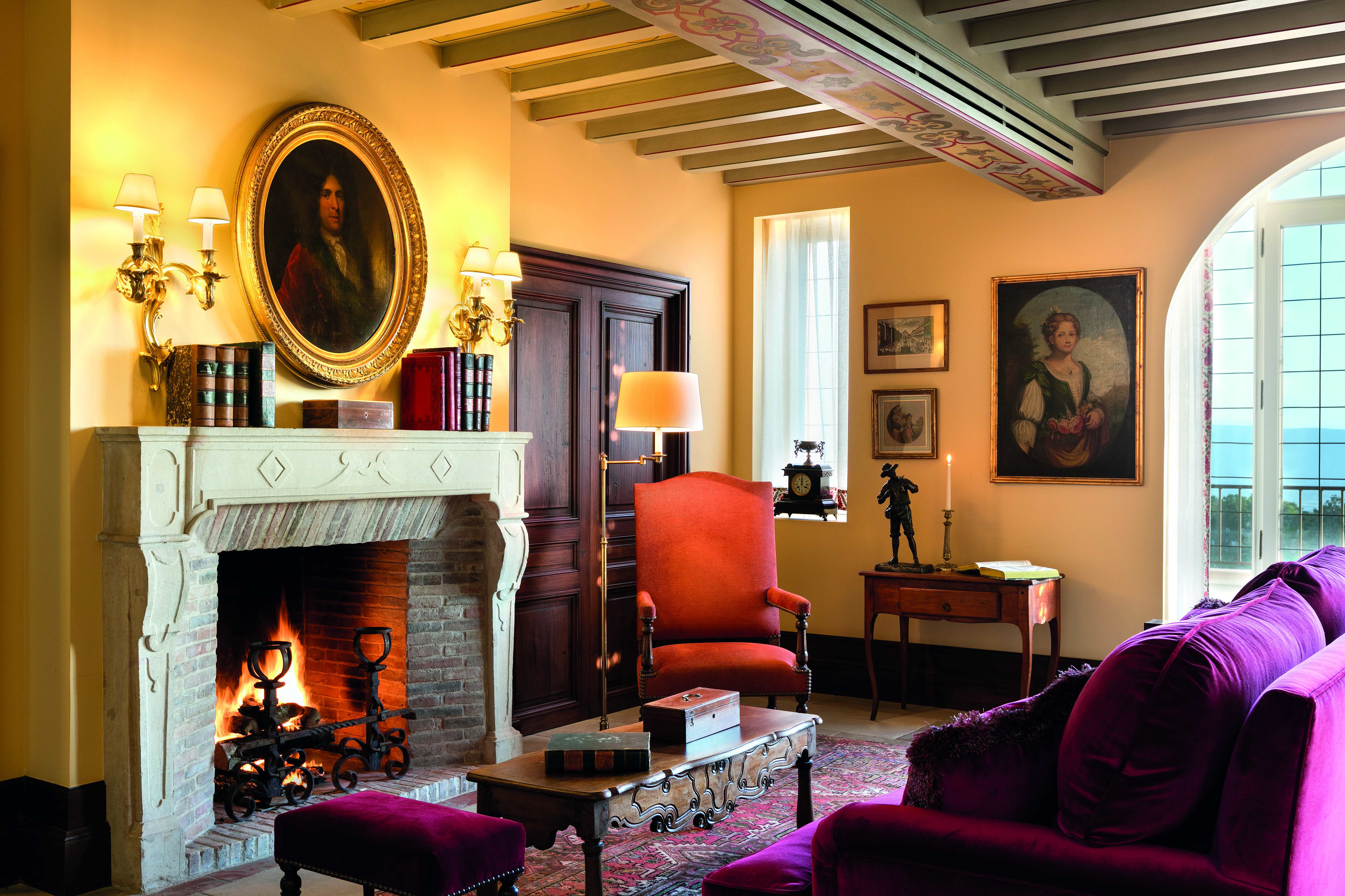 La Bastide de Gordes Provence lounge with sofa with two large paintings and a large fireplace