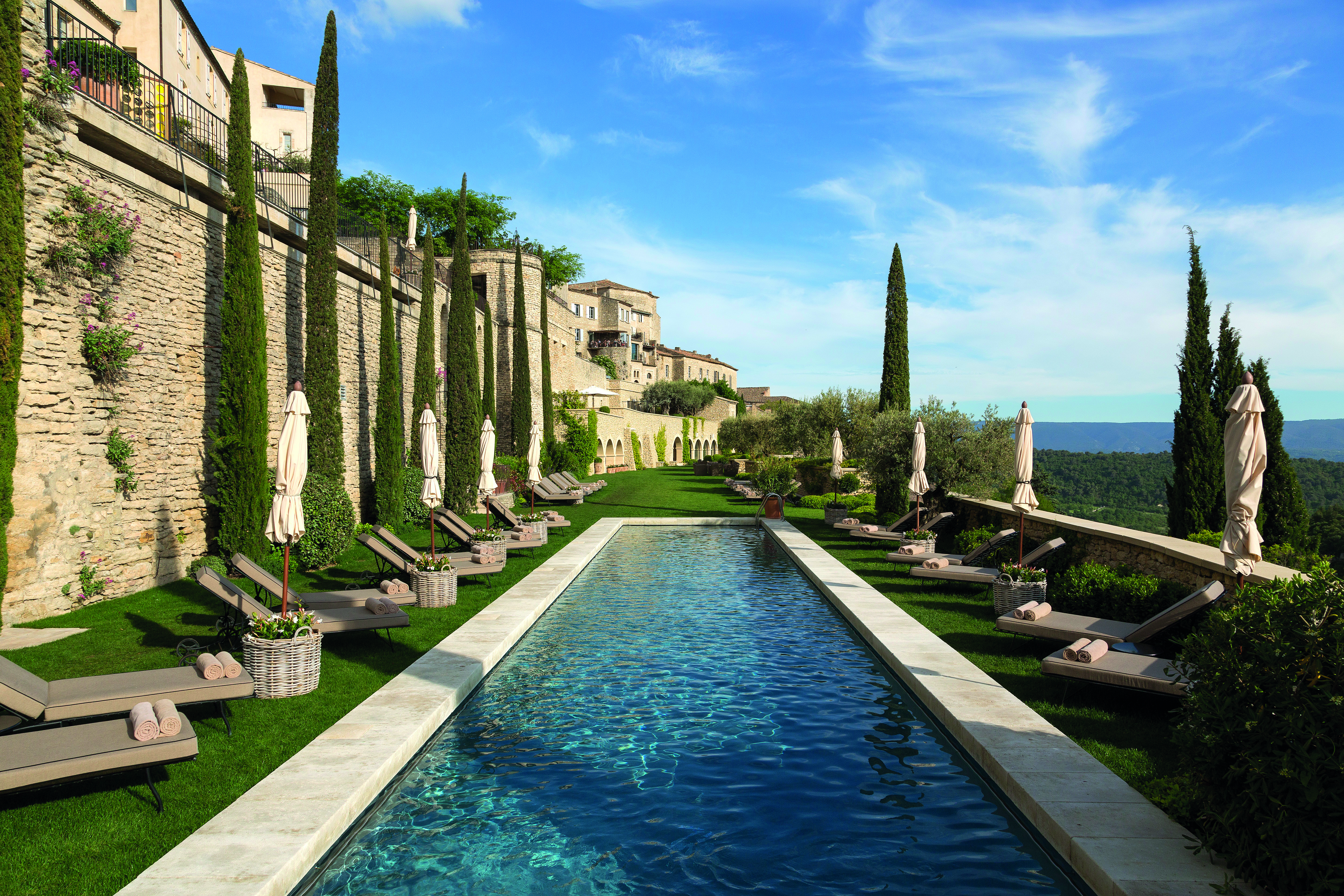 La Bastide de Gordes Provence outdoor swimming pool with sun loungers umbrellas and lawn area