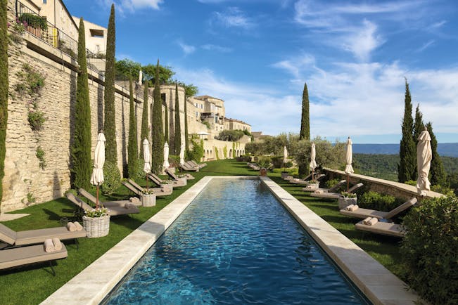 La Bastide de Gordes Provence outdoor swimming pool with sun loungers umbrellas and lawn area