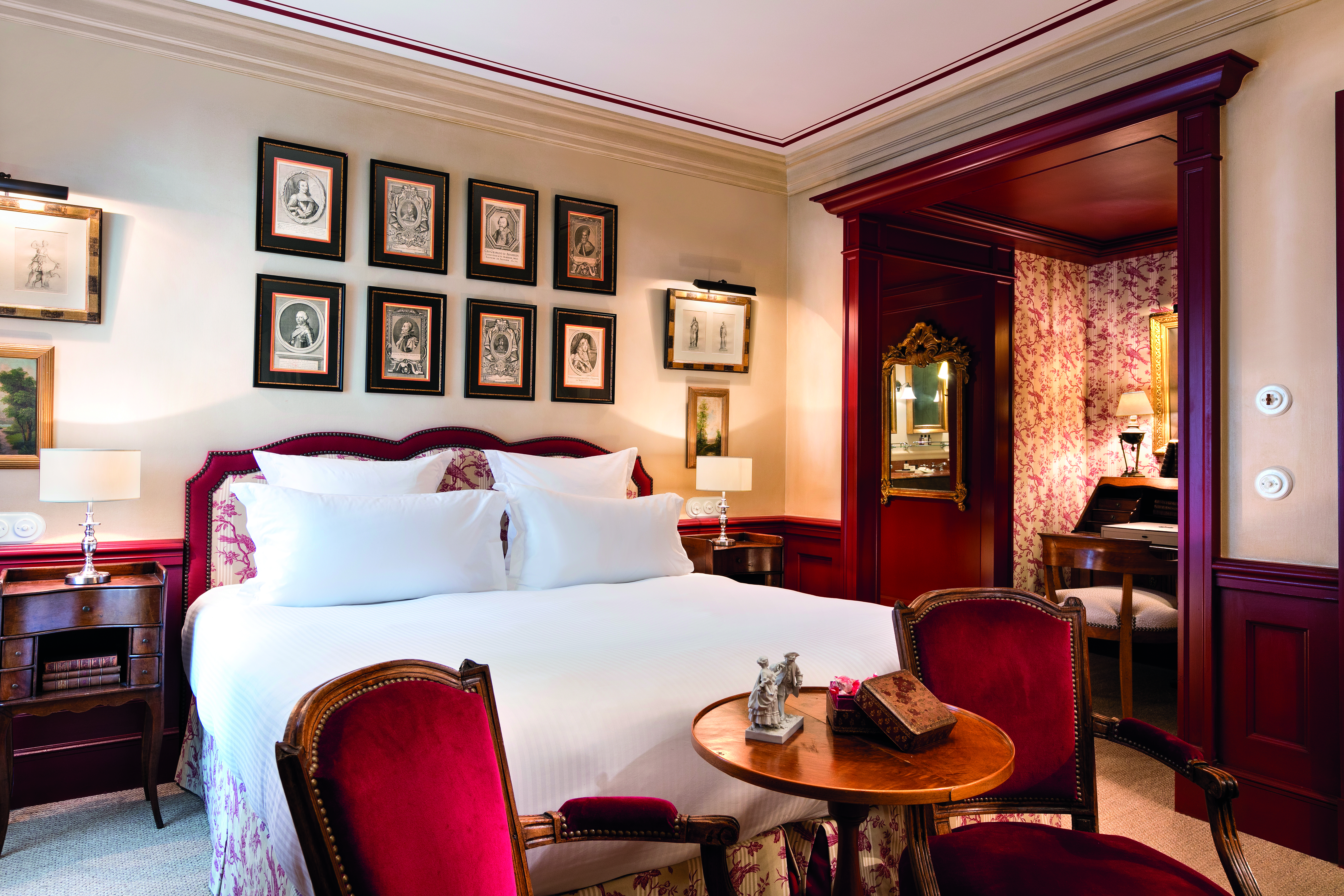 La Bastide de Gordes Provence superior bedroom with several paintings and a gold mirror