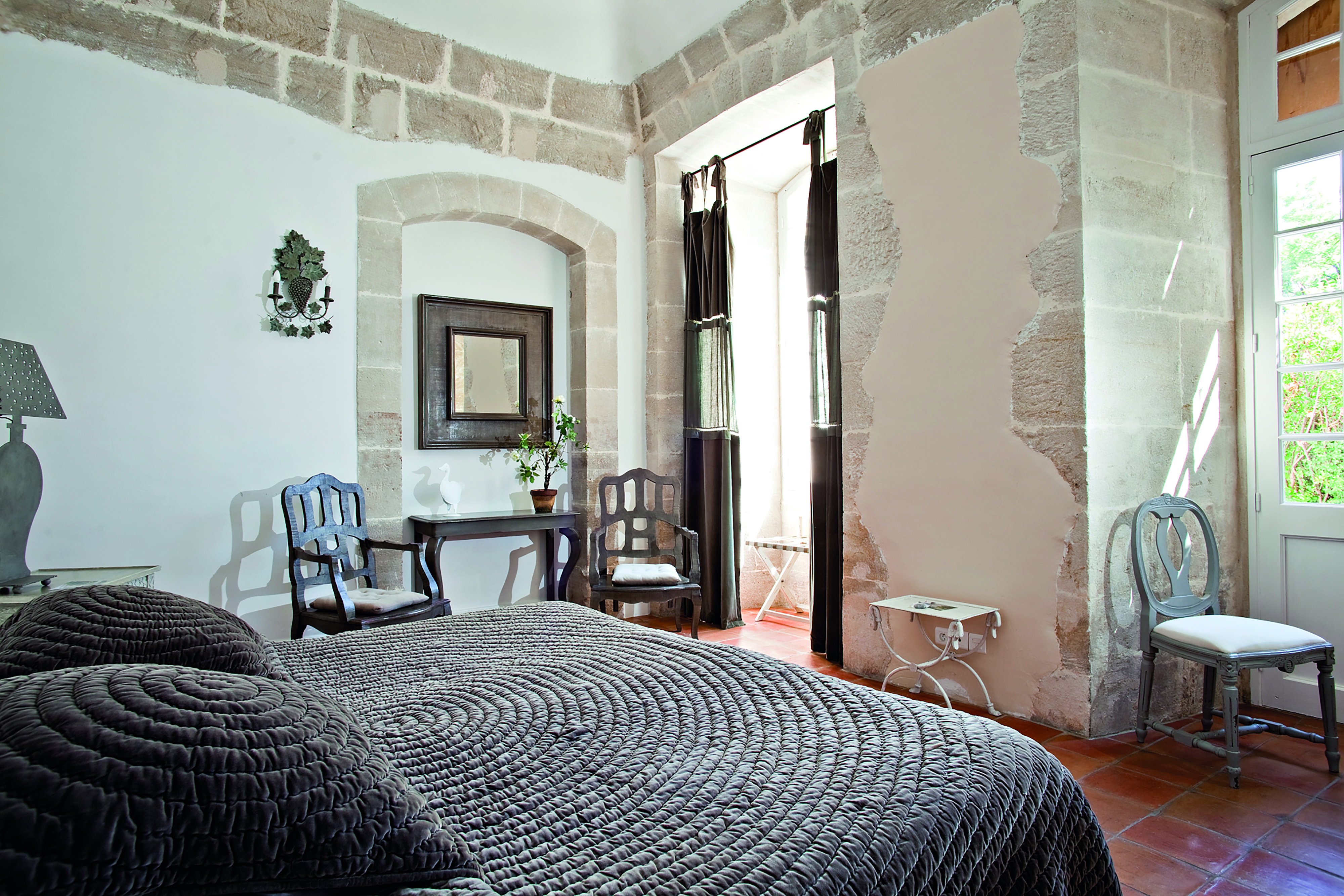 Chateau de Mazan Provence Jardin bedroom with exposed stone and a stone archway