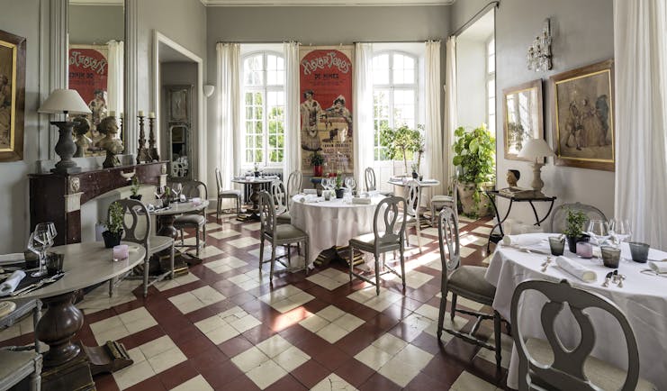Chateau de Mazan Provence restaurant dining area with a red and white tiled floor and a large red poster 