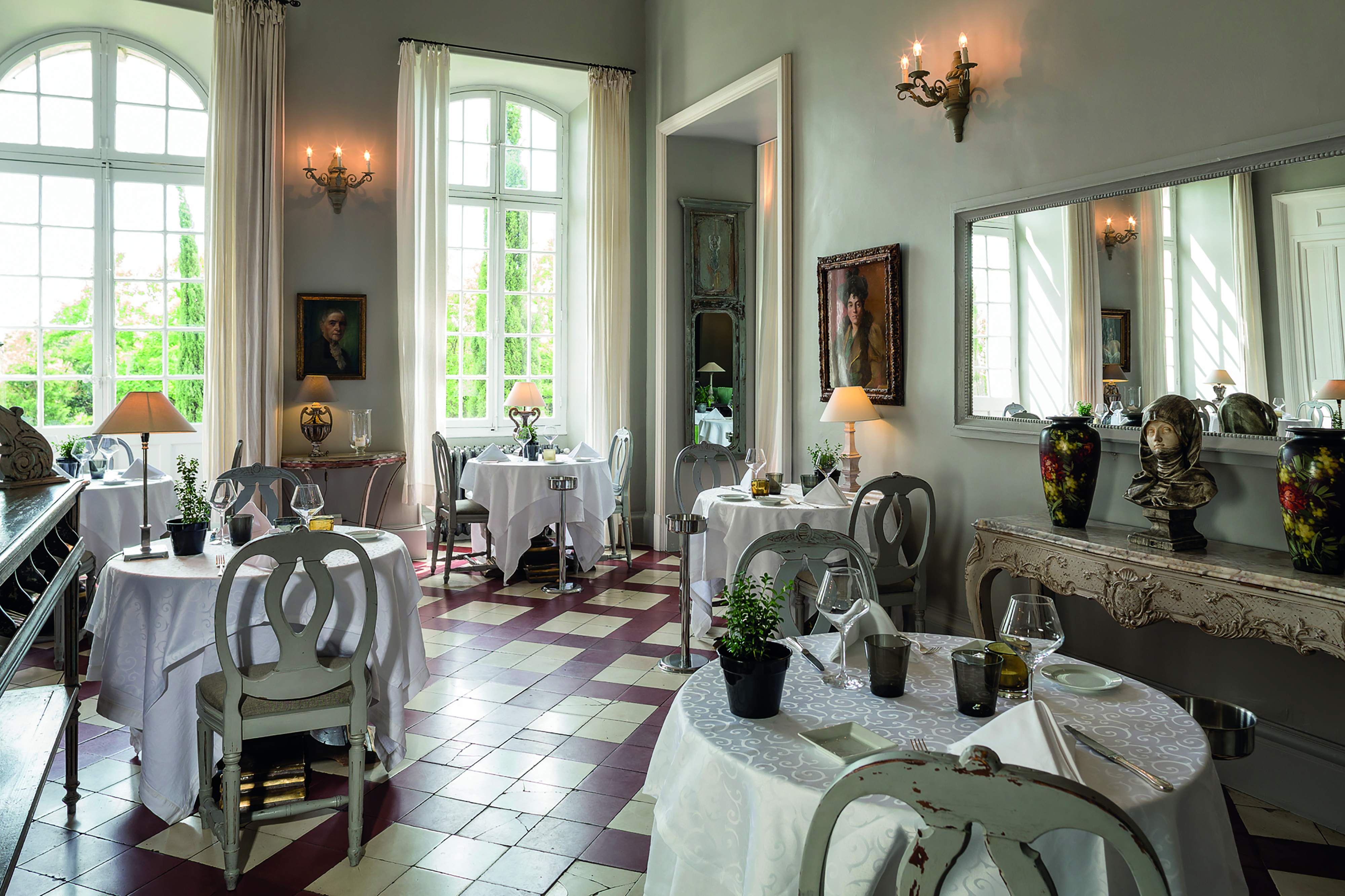 Chateau de Mazan Provence restaurant dining area with a side table with a bust and two vases
