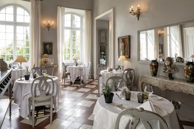 Chateau de Mazan Provence restaurant dining area with a side table with a bust and two vases