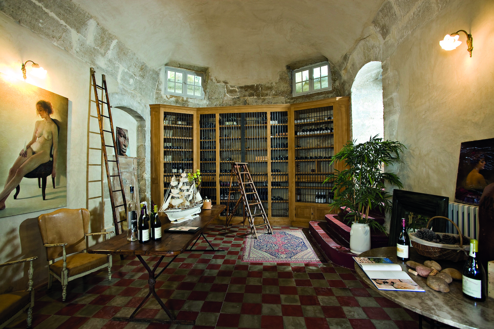 Chateau de Mazan Provence wine cellar with small ladders a chair and table with wine bottles