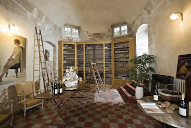 Chateau de Mazan Provence wine cellar with small ladders a chair and table with wine bottles