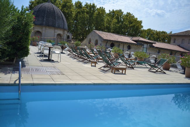 Le Cloitre Saint Louis Avignon rooftop pool with several wooden sun loungers