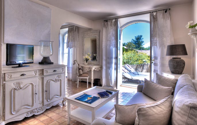Domaine de Capelongue Provence sitting room sofa cabinet and television door to a terrace with loungers