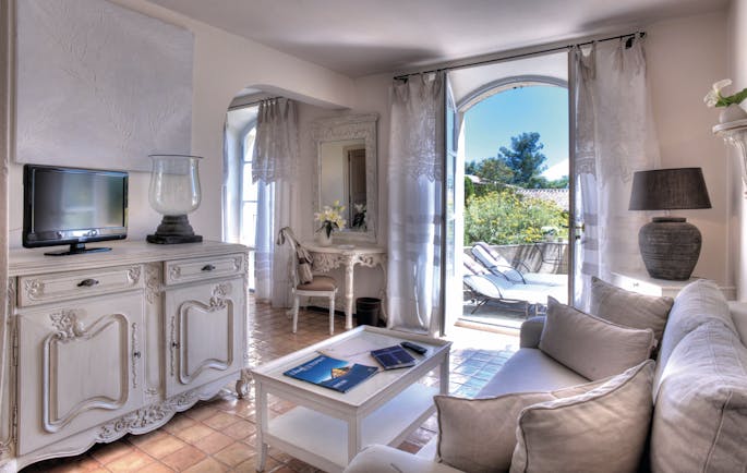 Domaine de Capelongue Provence sitting room sofa cabinet and television door to a terrace with loungers