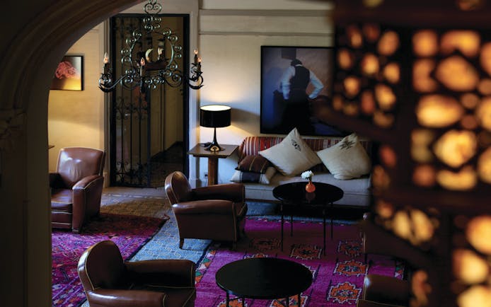 Grand Hotel Pinus Nord Provence lounge area with leather armchairs two photographs and a black chandelier